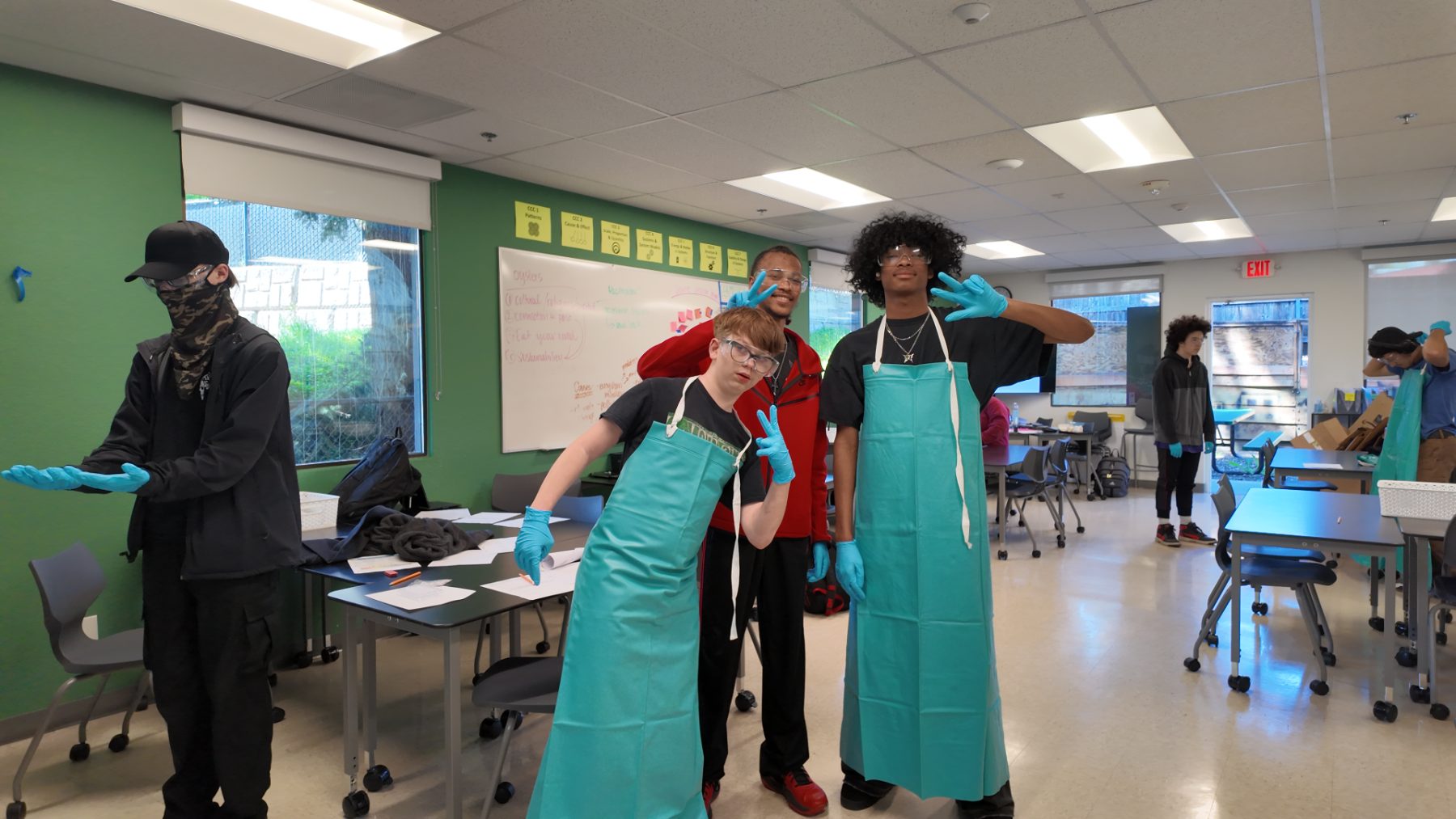 Students in lab aprons and gloves before a dissection